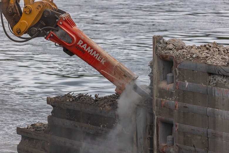 Construction workers make groundbreaking progress at a construction site at a navigational lock along a river.