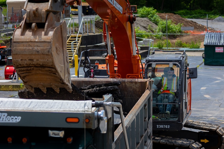 Construction workers make groundbreaking progress at a construction site at a navigational lock along a river.
