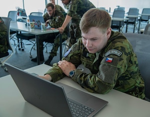 Uniformed Czech Republic soldier works on computer