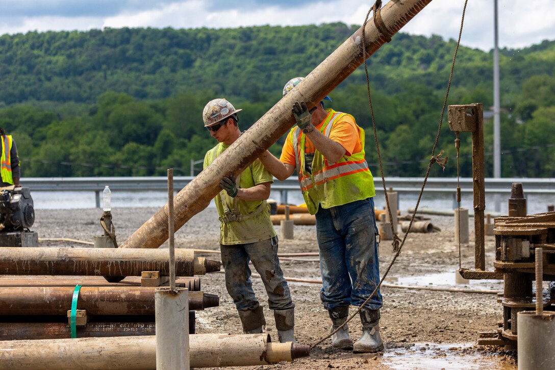Construction workers make groundbreaking progress at a construction site at a navigational lock along a river.