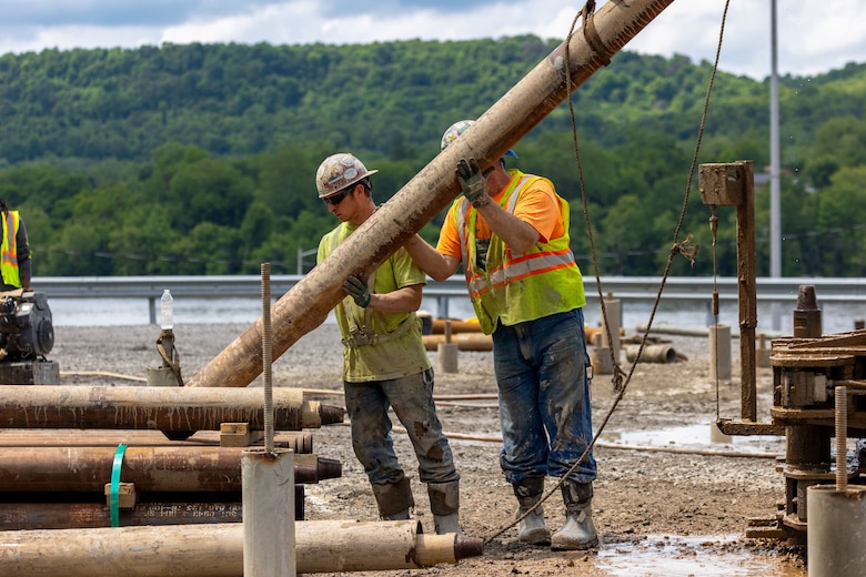 Construction workers make groundbreaking progress at a construction site at a navigational lock along a river.