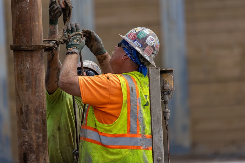 Construction workers make groundbreaking progress at a construction site at a navigational lock along a river.