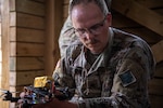 Sgt. Corey Fountain, a tactical unmanned aircraft system repairer assigned to Detachment 1, Delta Company, 545th Brigade Engineer Battalion, 45th Infantry Brigade Combat Team, prepares a small first-person view drone to be launched during a UAS exercise at Camp Gruber Training Center, Oklahoma, on June 12, 2025. The exercise, hosted by the 45th IBCT and featured numerous UAS and counter-UAS systems, focused on preparing infantry Soldiers to react to UAS threats. (Oklahoma National Guard photo by Staff Sgt. Anthony Jones)