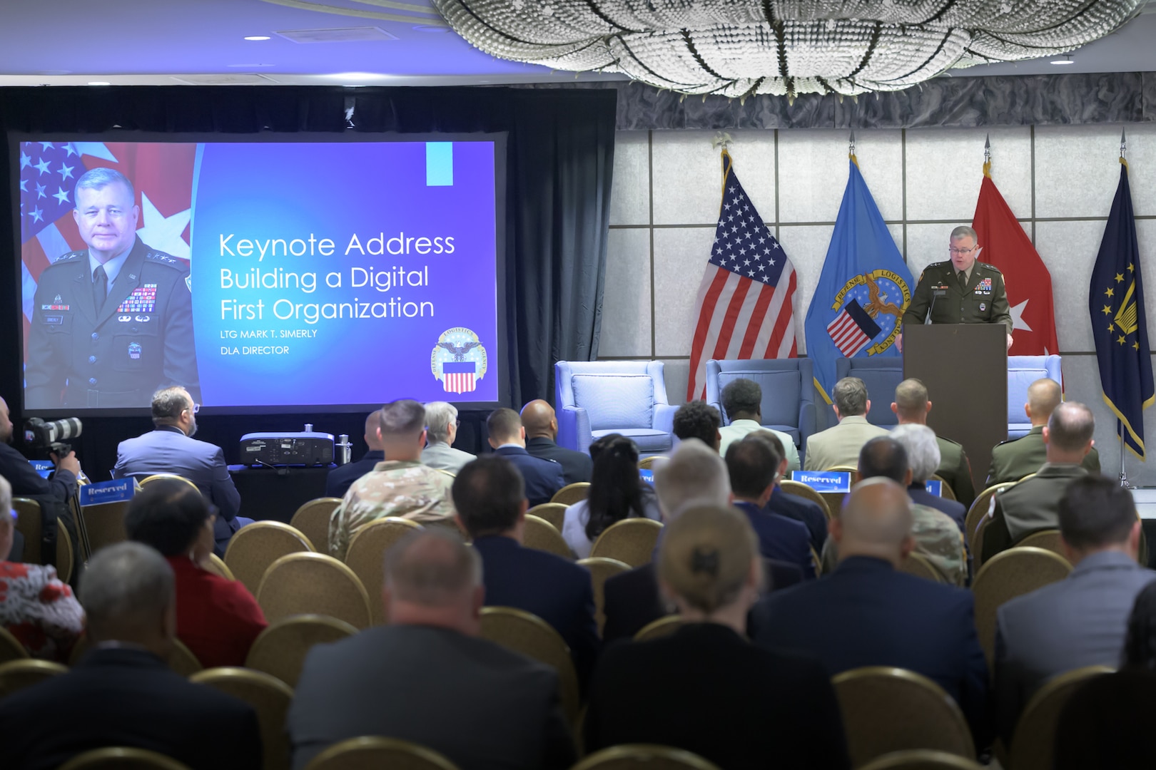 Defense Logistics Agency Director Army Lt. Gen. Mark Simerly at podium, speaking to attendees.
