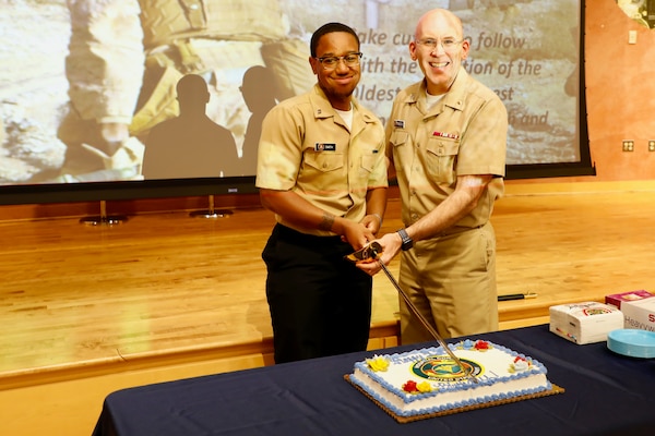 SILVER SPRING, Md. (June 11, 2025) Capt. Guillermo Pimentel, executive officer of Naval Medical Research Command (NMRC), and Seaman Paul Smith, cut a cake commemorating the 127th birthday of the U.S. Navy Hospital Corps. NMRC, headquarters of NMR&D, is engaged in a broad spectrum of activity from basic science in the laboratory to field studies in austere and remote areas of the world to investigations in operational environments. In support of Navy, Marine Corps and joint U.S. warfighter health, readiness and lethality, researchers study infectious diseases, biological warfare detection and defense, combat casualty care, environmental health concerns, aerospace and undersea medicine, operational mission support and epidemiology. For 250 years, Navy Medicine, represented by more than 44,000 highly-trained military and civilian healthcare professionals, has delivered quality healthcare and enduring expeditionary medical support to the warfighter on, below, and above the sea and ashore. (U.S. Navy photo by Sidney Hinds /Released)