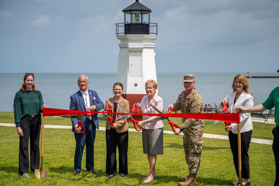 People stand with an Army Officer for a ceremonial ribbon-cutting in Vermilion, Ohio to mark completion of repairs to the city's West Pier and start of work on its East Pier.