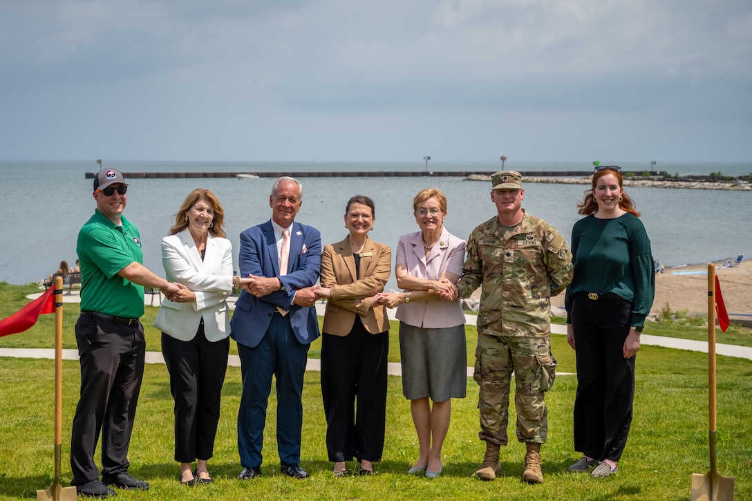People stand with an Army Officer for a ceremonial ribbon-cutting in Vermilion, Ohio to mark completion of repairs to the city's West Pier and start of work on its East Pier.