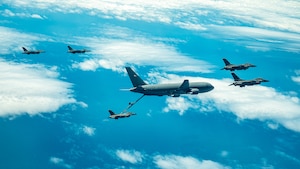 A KC-46 refuels F-16s