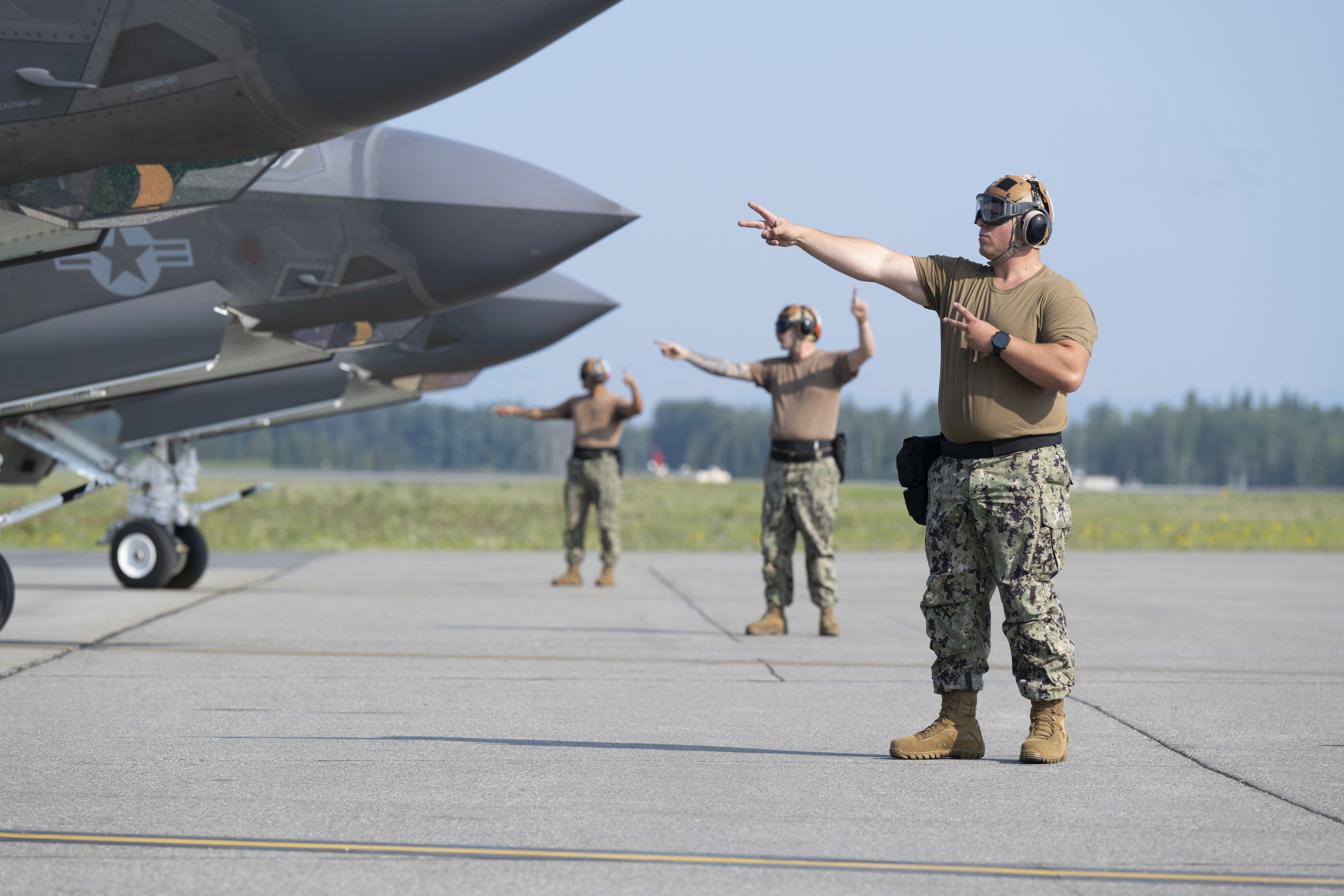 U.S. Navy Seaman Yevheniy Lyashenko, right, an Airframe Airman with the Strike Fighter Squadron (VFA) 86, signals to Lt. Austin “Chuck E Chaids” Douglas, VFA-86 F-35C pilot, during preflight checks during Red Flag-Alaska 25-2 at Eielson Air Force Base, Alaska, June 18, 2025. RF-A 25-2 brings Navy and Air Force personnel together to strengthen joint operations and advance shared readiness. (U.S. Air Force photo by Staff Sgt. Daniel Brosam)