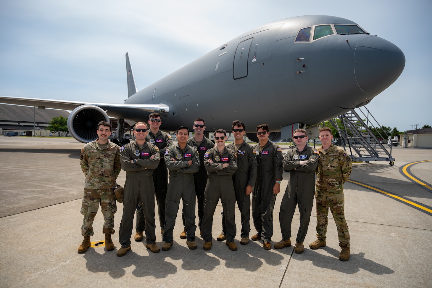 Airmen pose for a photo in front of a KC-46