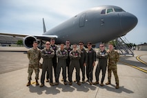 Airmen pose for a photo in front of a KC-46