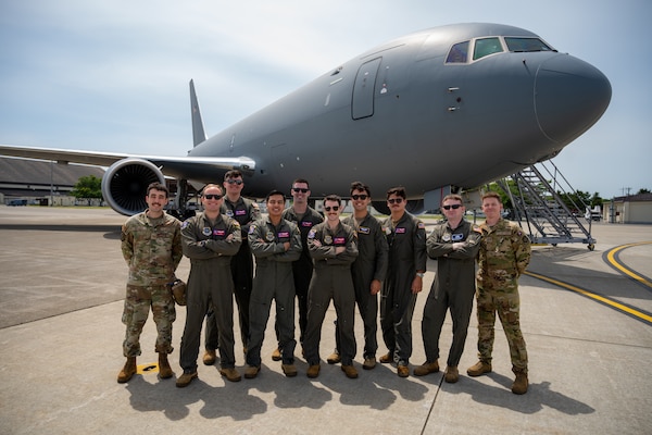 Airmen pose for a photo in front of a KC-46