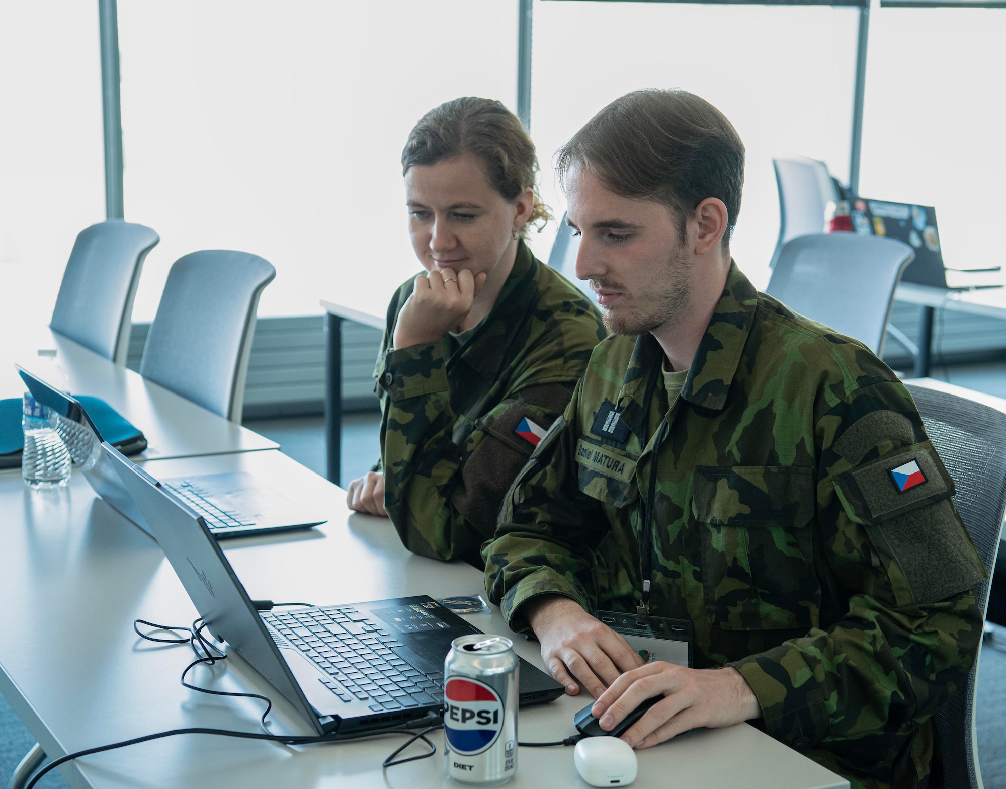Green uniformed members of the Czech Republic Armed Forces work on computers