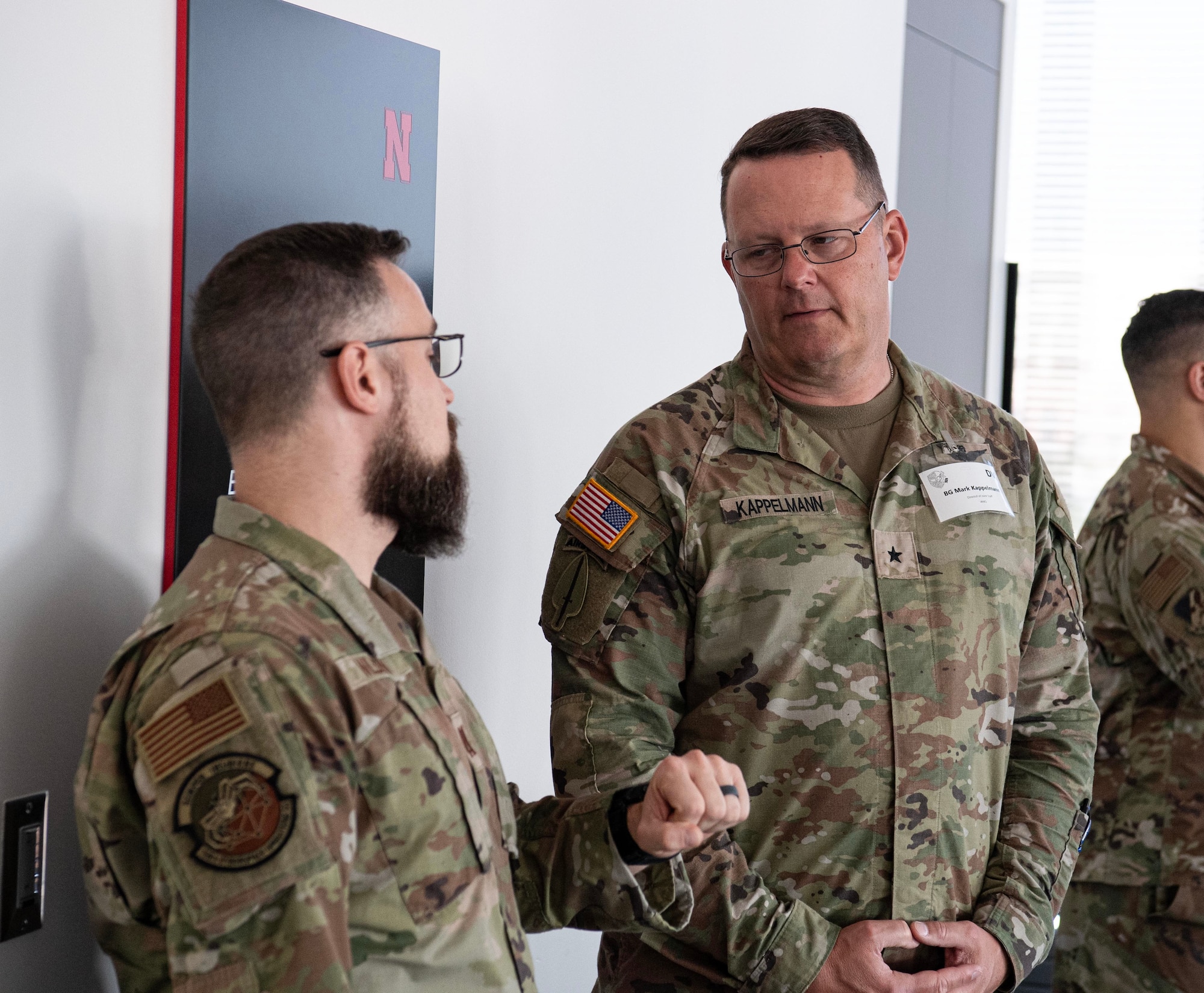 Two military men in green uniforms talk
