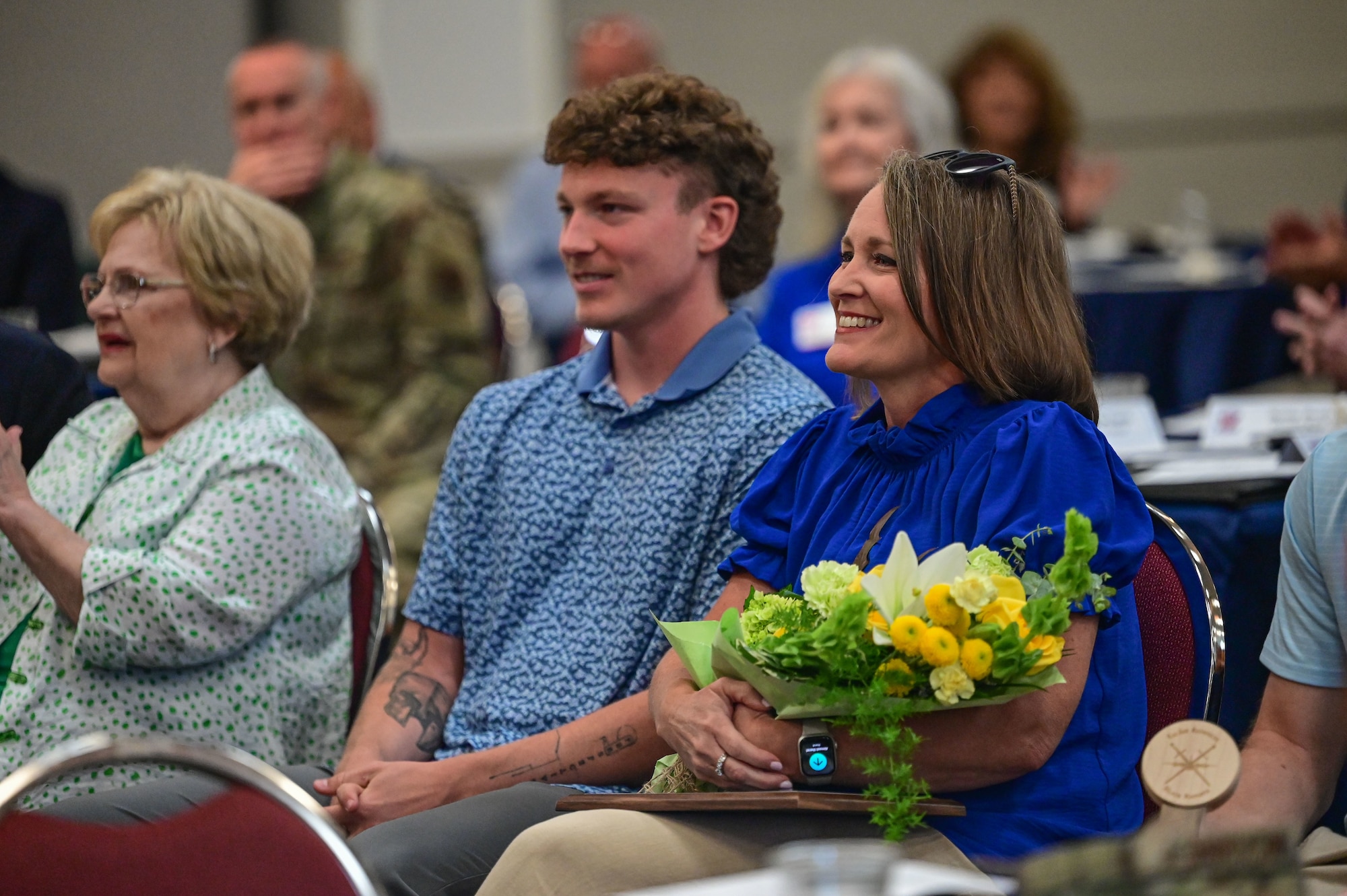Flowers are presented to the wife of Daniel Gray during an award presentation at the Jacksonville Community Center, Arkansas, June 17, 2025.