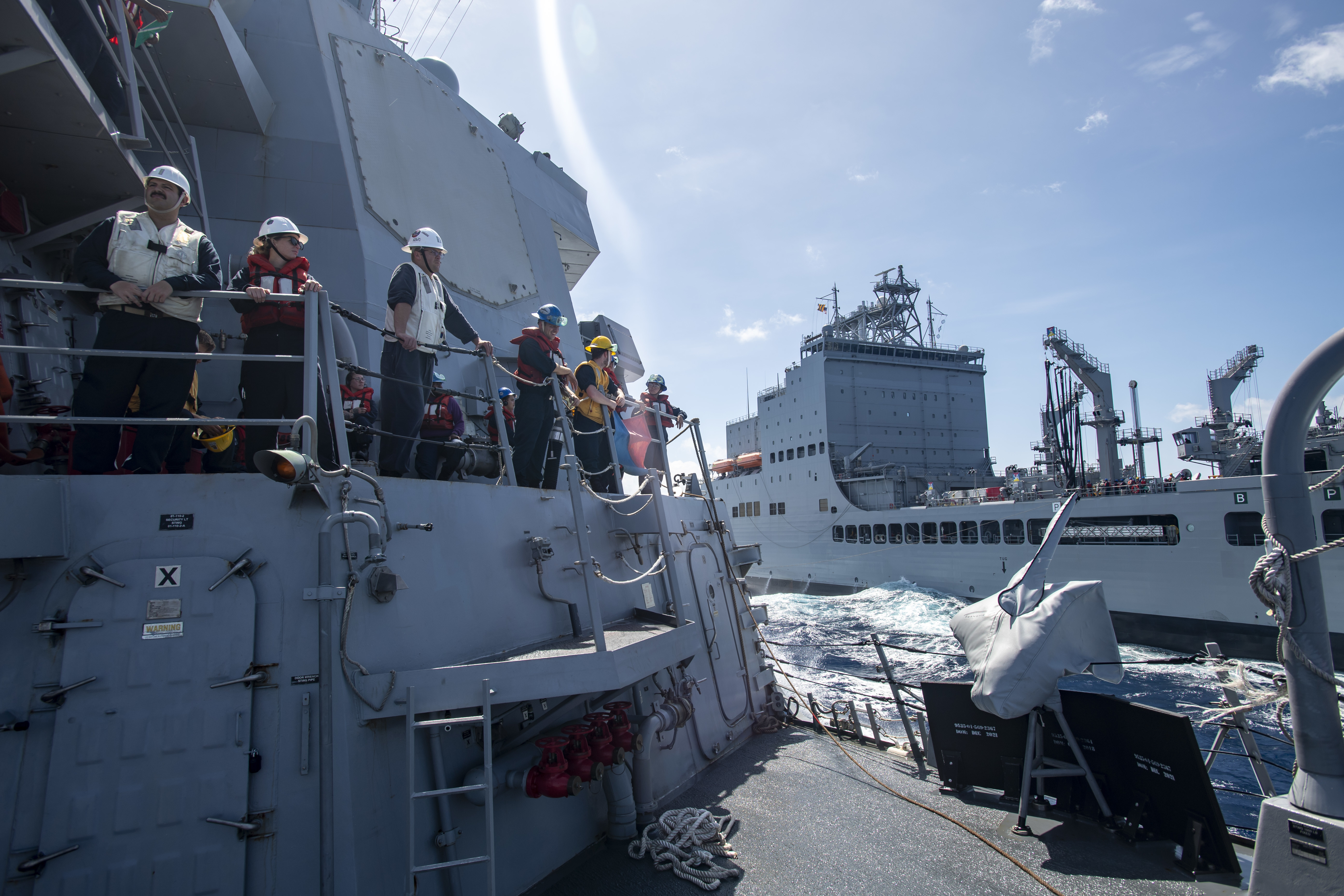 The Arleigh Burke-class guided-missile destroyer USS Lenah Sutcliffe Higbee (DDG 123) conducts a replenishment-at-sea with the fleet replenishment oiler USNS John Lewis (T-AO 205) in the South China Sea, June 13, 2025. The Higbee, assigned to the Nimitz Carrier Strike Group, is underway in the U.S. 7th Fleet area of operations on a scheduled deployment, demonstrating the U.S. Navy’s unwavering commitment to a free and open Indo-Pacific. (U.S. Navy photo by Mass Communication Specialist 2nd Class Peter K. McHaddad)