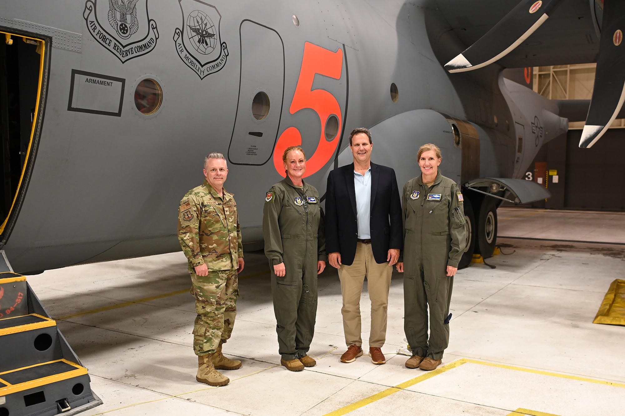 people pose in front of a C-130H Hercules