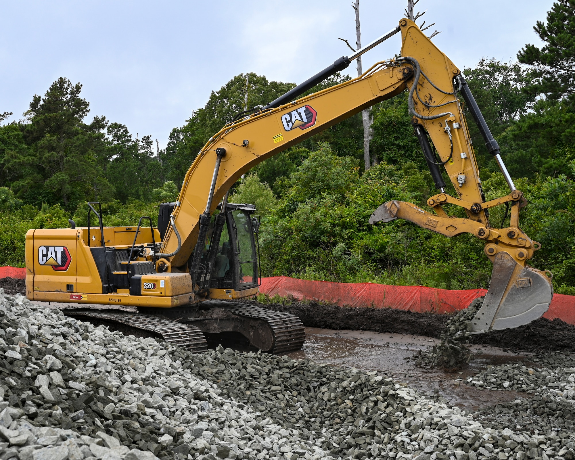 Pennsylvania Air National Guardsman, Senior Airman Asa Henderson assigned to the 171st Civil Engineer Squadron, operates an excavator to move riprap during a deployment for training, Assateague Island, Virginia, June 17, 2025. The 171st engineers are the 5th rotation of 8 during the deployment for training on the island. The DFT has provided engineers with unique training consistent with installing a runway while creating a new road for the Fish and Wildlife Service. (U.S. Air National Guard photo by Senior Master Sgt. Bryan Hoover)