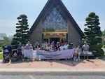 Service Members and Families of U.S. Forces Korea and United Nations Command gather for a group photo in front of Memorial Chapel in UN Memorial Cemetery in Korea, during the 2025 Korean Security, History, Cultural Immersion Program, June 18.