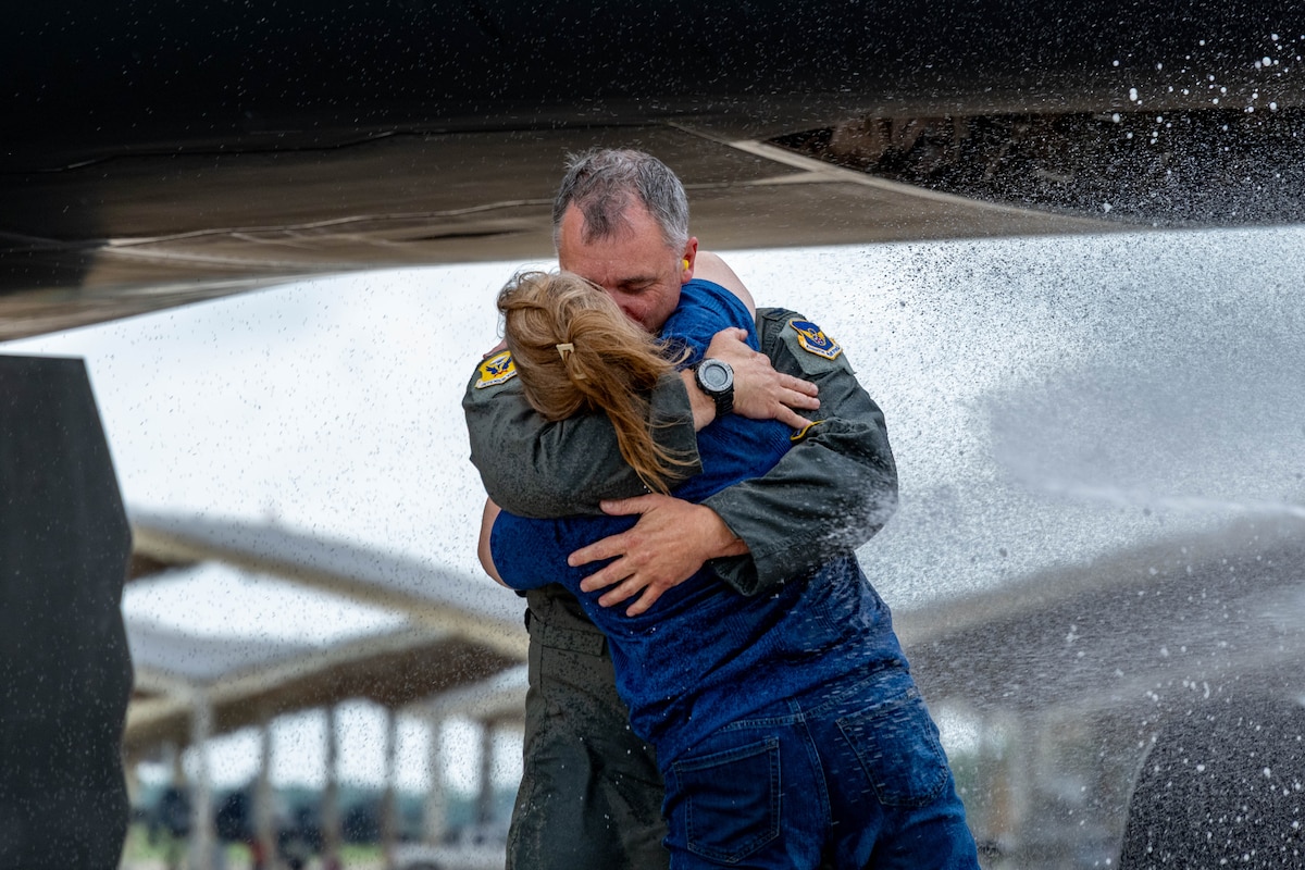 Col. Keith Butler, 509th Bomb Wing commander, embraces his wife, Diane Butler, after landing at Whiteman Air Force Base, Mo., June 6, 2025. Family and friends gathered to celebrate his final flight as wing commander. (U.S. Air Force photo by Senior Airman Bryson Sherard)