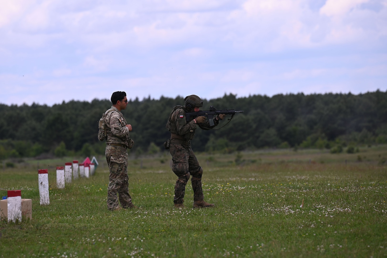 U.S. Army Sgt. Michael Rojas, a cavalry scout with C Troop, 2nd Squadron, 106th Cavalry Regiment, Illinois Army National Guard, observes as a Polish Territorial Defence soldier engages targets on a range near Toruń, Poland, June 7, 2025. The Illinois National Guard and Poland are partners in the Department of Defense National Guard State Partnership Program, which pairs Guard elements with partner nations worldwide for mutual training and subject matter expert exchanges. Servicemembers with the 33rd Infantry Brigade Combat Team are spending two weeks alongside their Polish counterparts training on sniper operations, the Javelin anti-tank weapon system, combat medical care, and remote observer techniques.