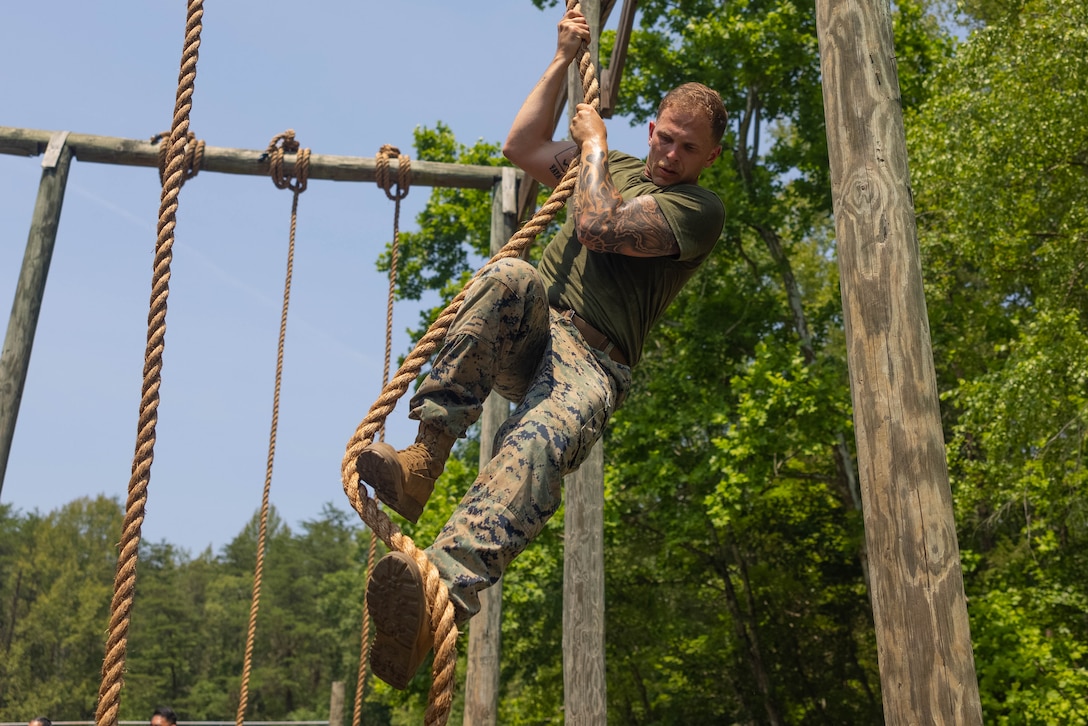 U.S. Marine Corps Sgt. Alex Brinkley, a student of the Force Fitness Instructor Course, climbs the rope at the obstacle course on Marine Corps Base Quantico, Virginia, June 12, 2025. The FFI course trains Marines to improve their warfighting capability to maximize unit physical readiness and optimize mental and physical performance. (U.S. Marine Corps photo by Pfc. Camila Garibay)