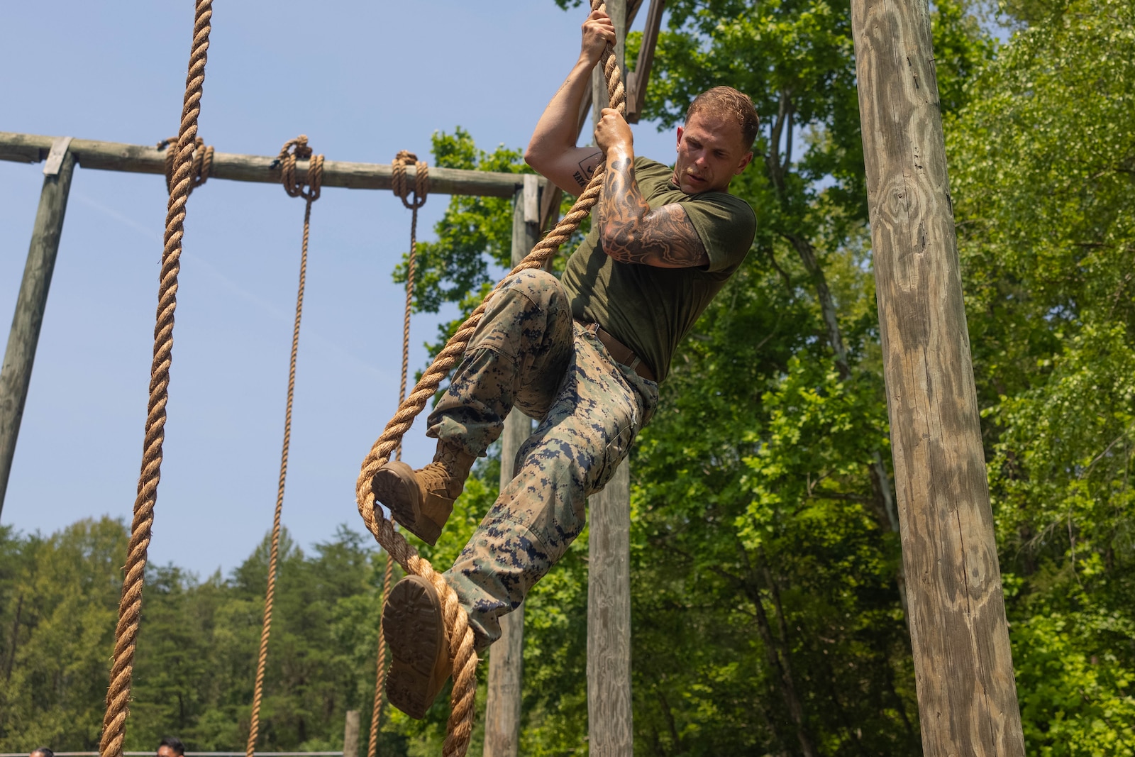 U.S. Marine Corps Sgt. Alex Brinkley, a student of the Force Fitness Instructor Course, climbs the rope at the obstacle course on Marine Corps Base Quantico, Virginia, June 12, 2025. The FFI course trains Marines to improve their warfighting capability to maximize unit physical readiness and optimize mental and physical performance. (U.S. Marine Corps photo by Pfc. Camila Garibay)