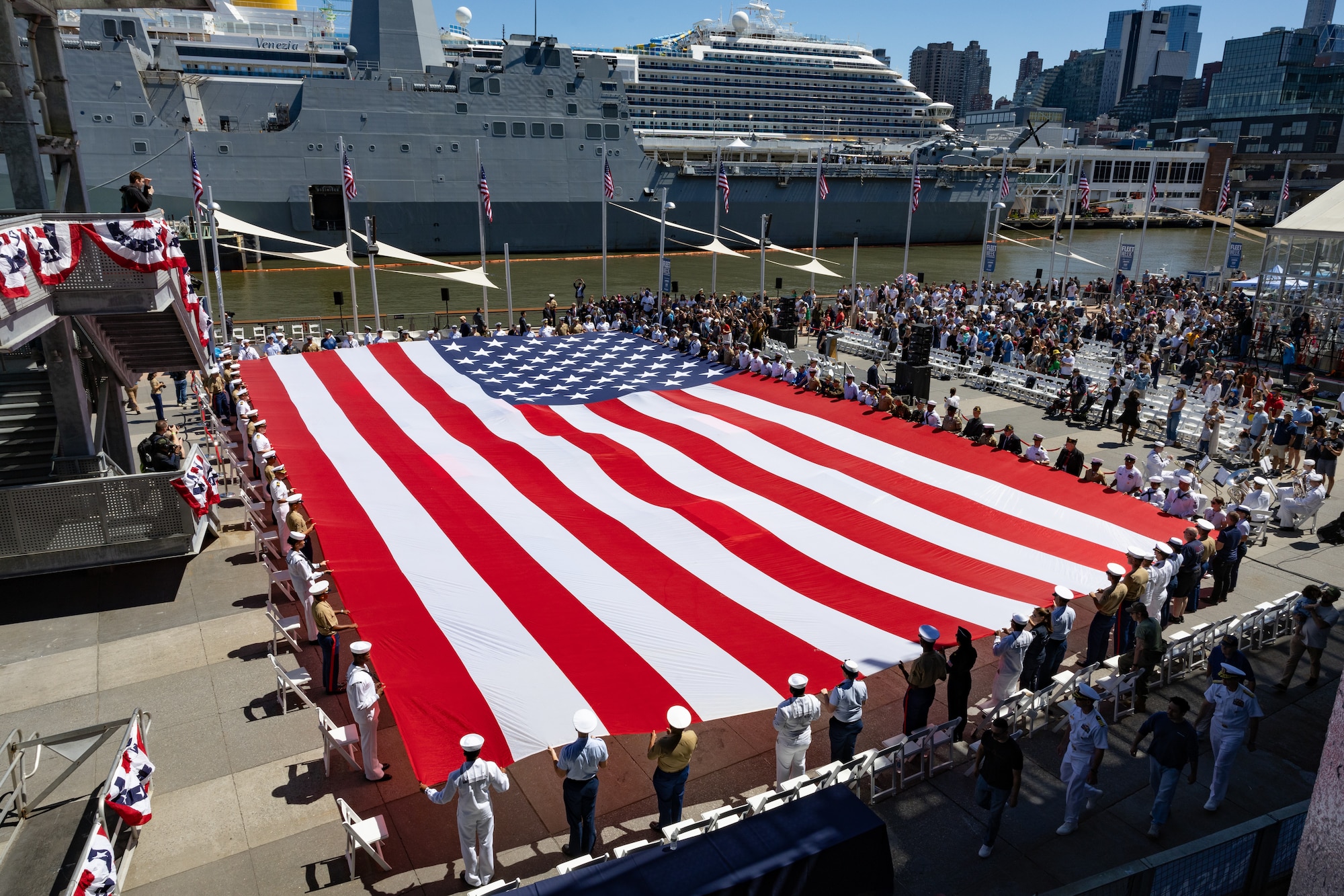 U.S. Navy Sailors, Marines, Coast Guardsmen and Veterans hold on to the American flag during the Memorial Day ceremony at the Intrepid Sea, Air & Space Museum during Fleet Week New York May 26, 2025. America’s warfighting Navy and Marine Corps celebrate 250 years of protecting American prosperity and freedom. Fleet Week New York 2025 honors the Navy, Marine Corps, and Coast Guard’s enduring role on, under, and above the seas. (U.S. Navy photo by Mass Communication Specialist 2nd Class Jahlena Riveraroyer)