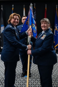 U.S. Air Force Col. Angelina Maguinness, 17th Training Wing commander, passes the guidon to Col. La Rita Abel, 17th Medical Group commander, during the change of command ceremony at the Powell Event Center, Goodfellow Air Force Base, Texas, June 18, 2025. The passing of the guidon is a military tradition that dates back to the time of Frederick the Great of Prussia. (U.S. Air Force photo by Airman 1st Class Brian Lummus)