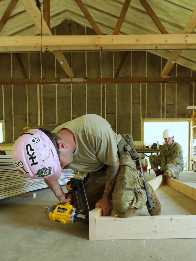 Spc. Zenon Mineo (left) and Sgt. Josh Cabral, both of the Maine Army National Guard’s 185th Engineer Support Company, frame up a roof support for the Lake George Regional Park’s visitor center near Skowhegan, Maine, June 8, 2025.