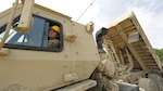 Spc. Clyde Carr of the 185th Engineer Company dumps his carry of old fill at a construction site at the old Great Northern Paper Company in East Millinocket, Maine, June 9, 2025. The unit is spending their annual training doing site improvements as part of an innovative readiness training project, a collaboration between the Maine National Guard and the town of East Millinocket.