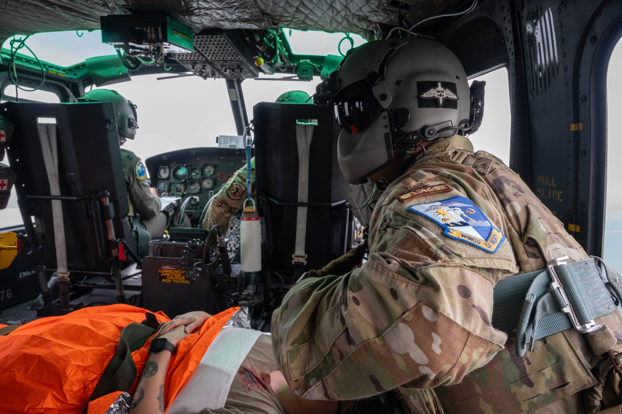 Airmen from the 54th Helicopter Squadron (54HS) transport a volunteer patient to a simulated field hospital during a training event at Minot Air Force Base, North Dakota, June 11, 2025. The 54HS participated in the training exercise to enhance trust and communication between medics and aircrew during patient handoff or in-flight care. (U.S. Air Force photo by Airman 1st Class Wesley Davies)