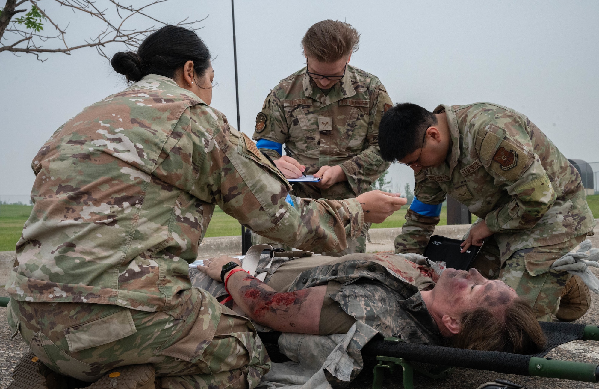 Airmen from the 5th Medical Group assess and treat simulated injuries for a training event at Minot Air Force Base, North Dakota, June 11, 2025. The 5MDG gathered volunteers to wear moulage makeup to participate in training Airmen with assessing and treating injuries. (U.S. Air Force photo by Airman 1st Class Wesley Davies)