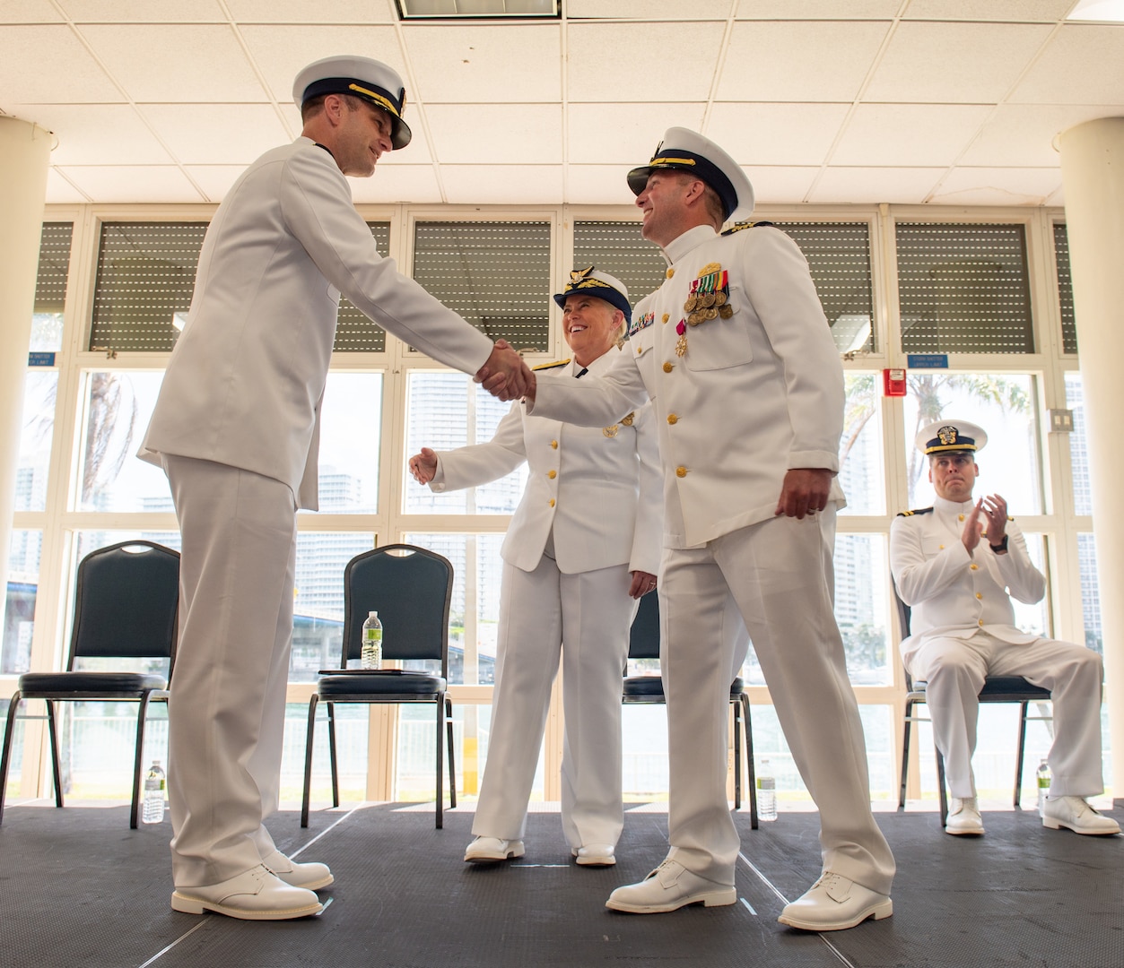 Military members shake hands at a ceremony