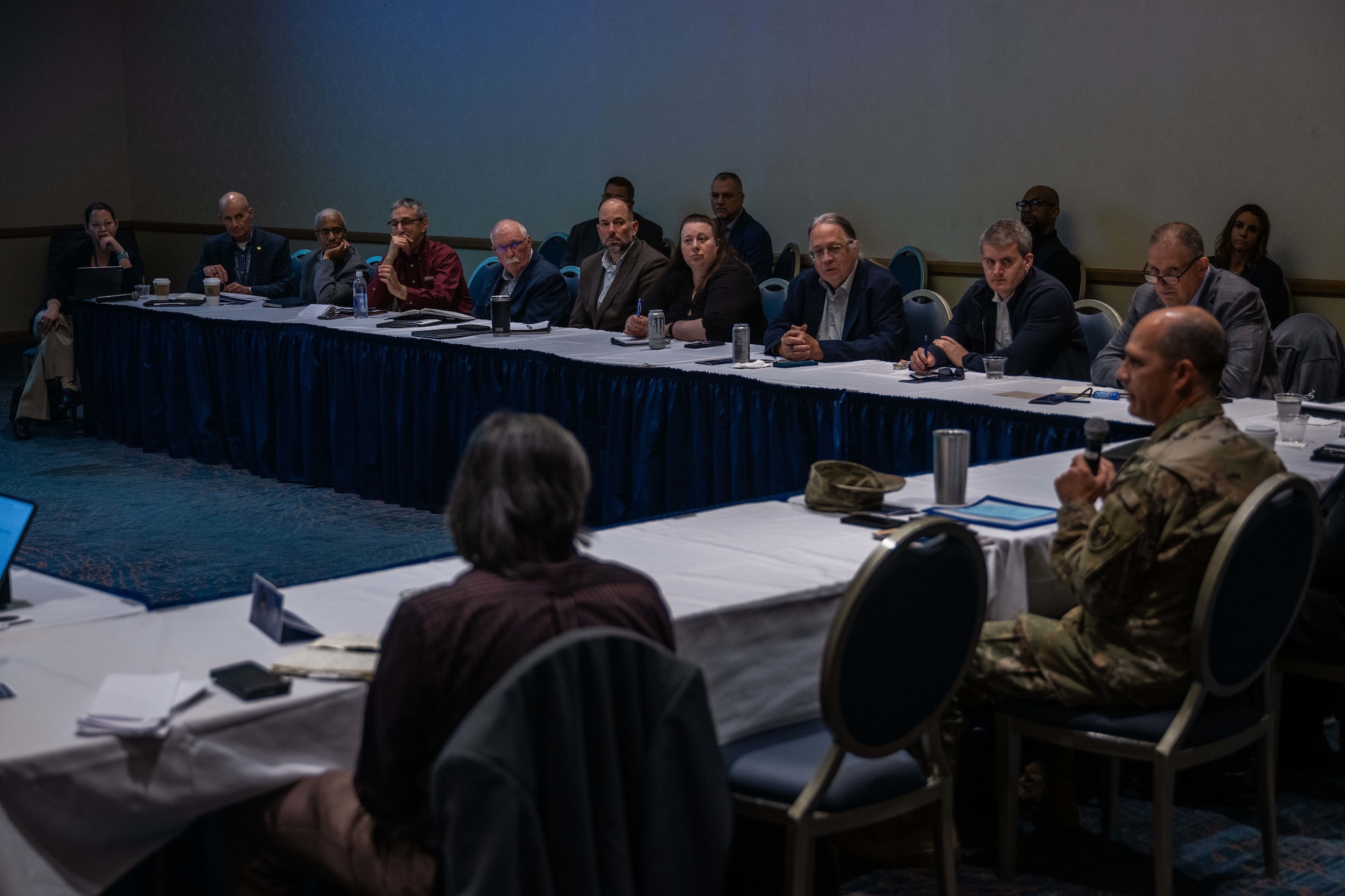 A room full of people listen to remarks from an Army General.