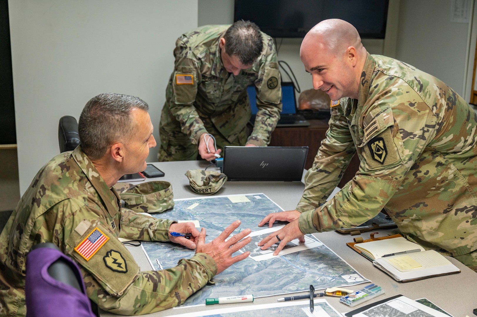 photos of the adjutant general in uniform talking at a press conference with the governor, visiting people, sitting around a conference table.