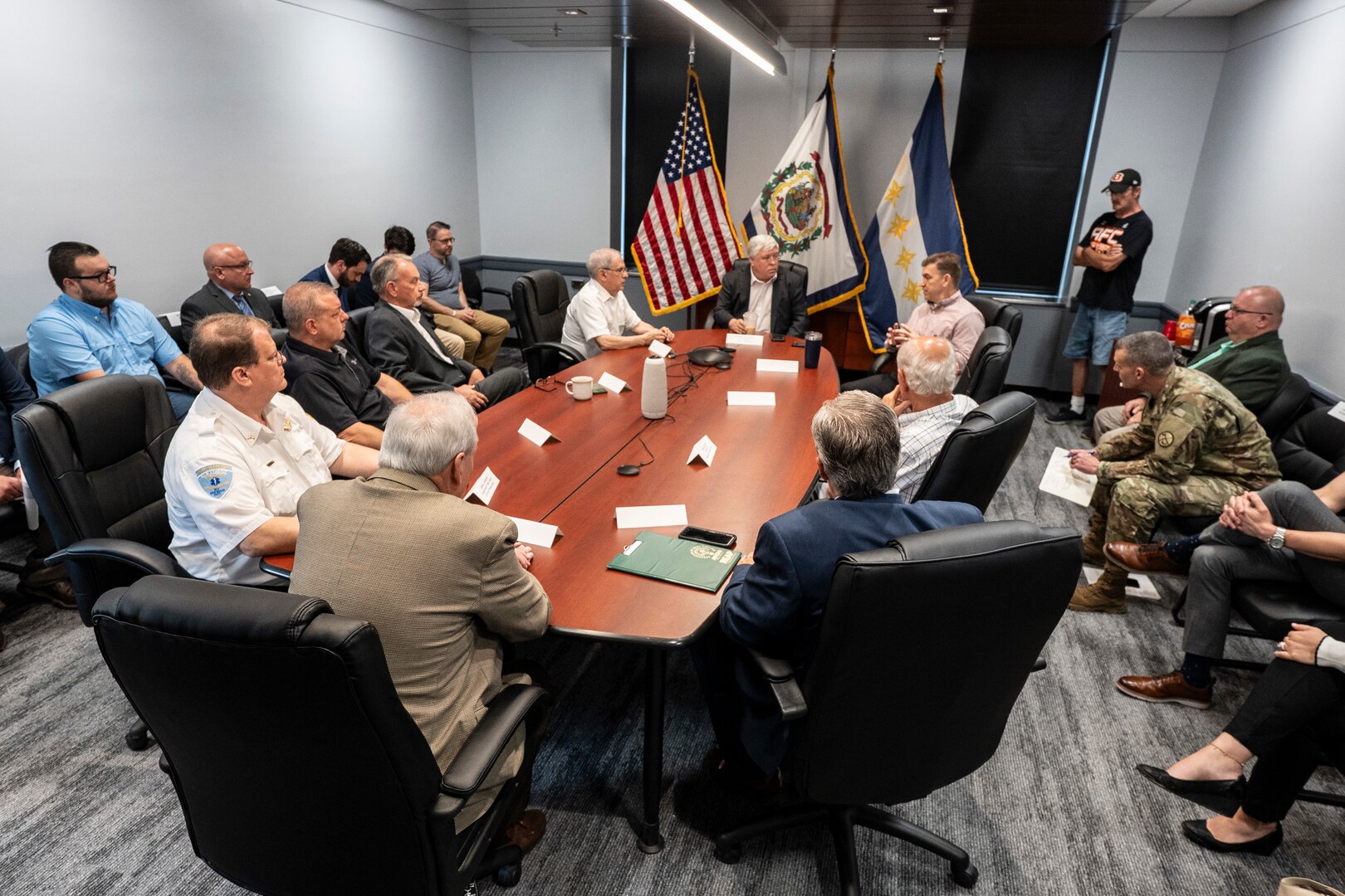 photos of the adjutant general in uniform talking at a press conference with the governor, visiting people, sitting around a conference table.
