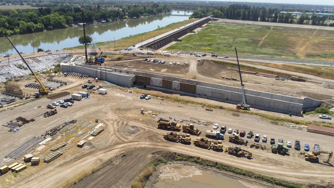 An aerial view shows construction of the fish passage structure along the west bank of the Sacramento River in Yolo County, California, on May 14, 2025. The structure is part of the Sacramento Weir Widening Project managed by the U.S. Army Corps of Engineers Sacramento District, which will create an 8,600-foot "double hybrid technical fishway" for endangered salmon, steelhead and sturgeon. The $350 million project combines flood control infrastructure with fish passage capabilities to protect threatened species during high-water events.