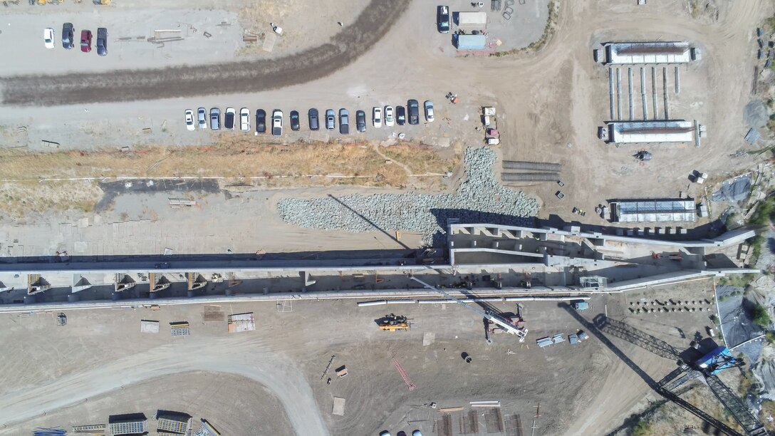 An overhead aerial view shows construction of the fish passage structure along the west bank of the Sacramento River in Yolo County, California, on June 5, 2025. The structure is part of the Sacramento Weir Widening Project managed by the U.S. Army Corps of Engineers Sacramento District, which will create an 8,600-foot "double hybrid technical fishway" for endangered salmon, steelhead and sturgeon. The $350 million project combines flood control infrastructure with fish passage capabilities to protect threatened species during high-water events.