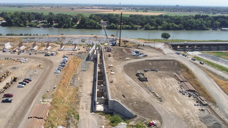 An aerial view shows construction of the fish passage structure along the west bank of the Sacramento River in Yolo County, California, on June 5, 2025. The structure is part of the Sacramento Weir Widening Project managed by the U.S. Army Corps of Engineers Sacramento District, which will create an 8,600-foot "double hybrid technical fishway" for endangered salmon, steelhead and sturgeon. The $350 million project combines flood control infrastructure with fish passage capabilities to protect threatened species during high-water events.