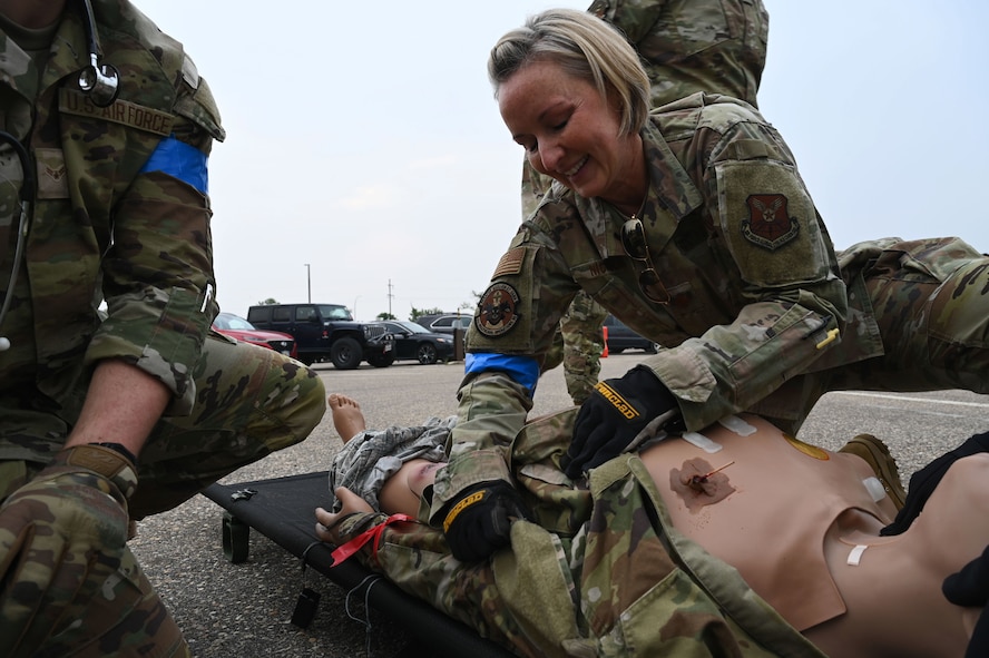 U.S. Air Force Maj. Jamie Nicholas, 5th Medical Group (5MDG) clinical nurse, demonstrates how to perform a medical maneuver on a manikin at Minot Air Force Base, North Dakota, June 11, 2025. The 5MDG holds training once a week to teach Airmen new skills and to reinforce previously taught skills such as wound recognition and treatment. (U.S. Air Force photo by Airman 1st Class Anthony Ramey.)