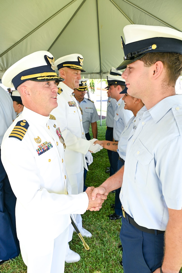 Capt. Jason Ingram and Capt. Joshua Empen, outgoing and incoming Sector Key West commanders, 
inspect crewmembers of Sector Key West during a change of command ceremony held in Key West, June 20, 2025. The inspection of a crew is a time-honored military tradition when passing unit command from one officer to another. (U.S. Coast Guard photo by Petty Officer 2nd Class Eric Rodriguez)