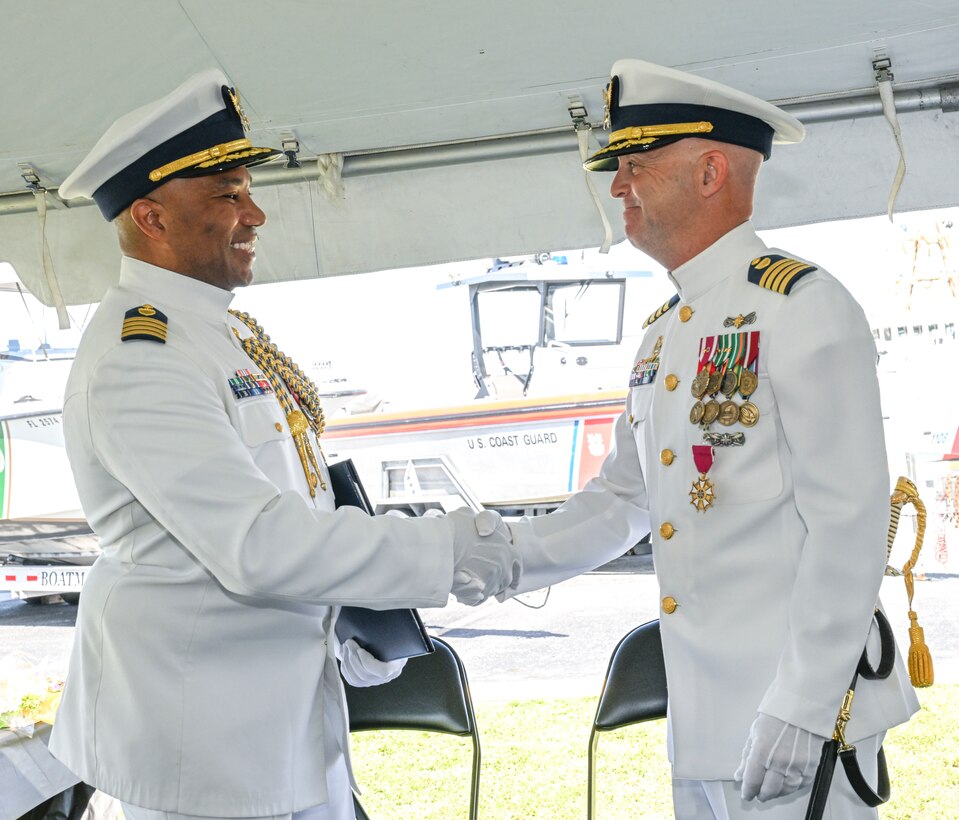 Capt. Willie L. Carmichael, Seventh Coast Guard District chief of staff, shakes hands with Capt. Jason Ingram, former commander of Sector Key West, during a change of command ceremony held in Key West, June 20, 2025. Capt. Carmichael served as the presiding senior officer over the ceremony honoring a military tradition and the transfer of authority from the outgoing commander to the incoming commander. (U.S. Coast Guard photo by Petty Officer 2nd Class Eric Rodriguez