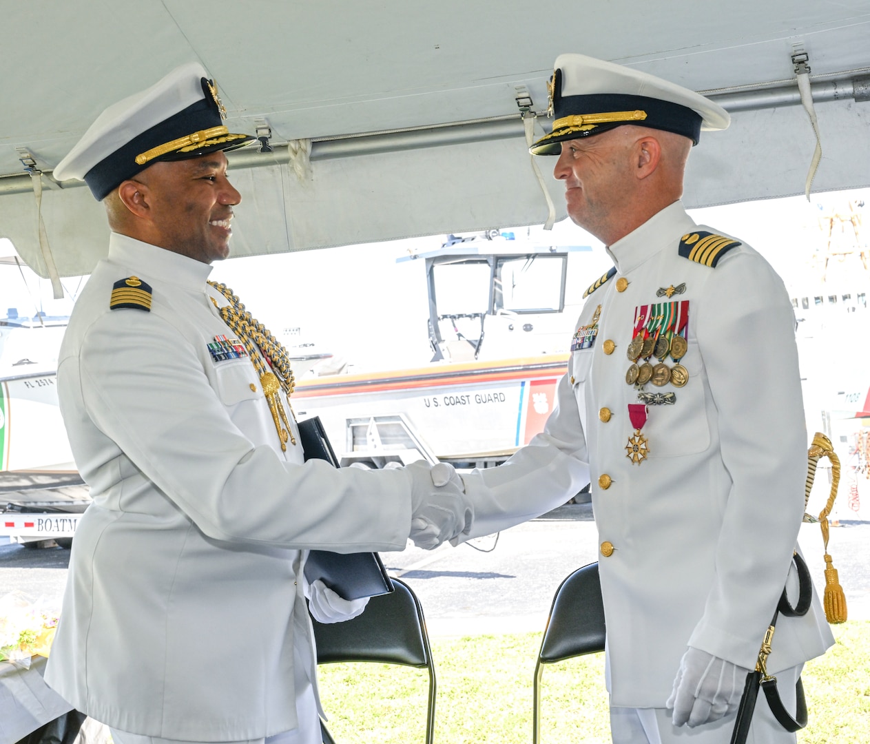 Capt. Willie L. Carmichael, Seventh Coast Guard District chief of staff, shakes hands with Capt. Jason Ingram, former commander of Sector Key West, during a change of command ceremony held in Key West, June 20, 2025. Capt. Carmichael served as the presiding senior officer over the ceremony honoring a military tradition and the transfer of authority from the outgoing commander to the incoming commander. (U.S. Coast Guard photo by Petty Officer 2nd Class Eric Rodriguez