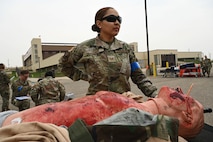 U.S. Air Force Staff Sgt. Jamila Jones, a 5th Medical Group (5MDG) medical technician, poses in front of a manikin at Minot Air Force Base, North Dakota, June 11, 2025. The 5MDG used manikins to assist in training Airmen to assess and treat injuries. (U.S. Air Force photo by Airman 1st Class Anthony Ramey.)