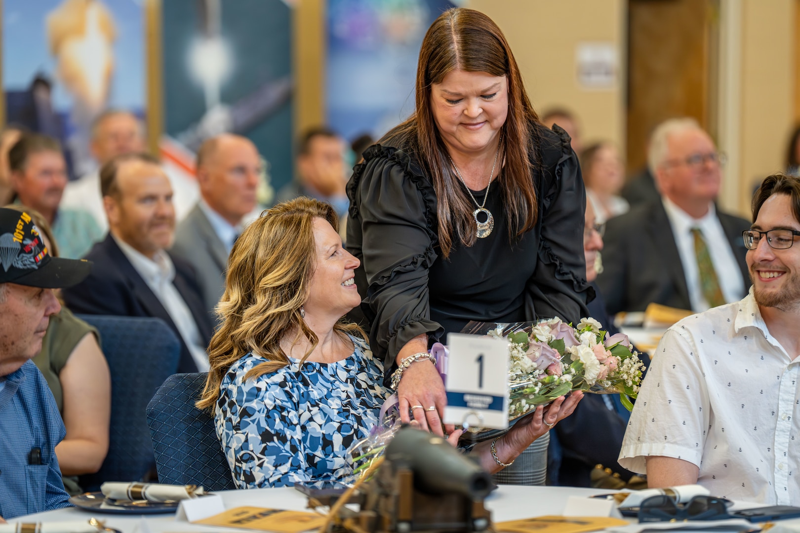 KING GEORGE, Va. – Naval Surface Warfare Center Dahlgren Division Administrative Officer Trina Harris presents flowers to Tina Sisson, wife of Technical Director Dale Sisson Jr., during his retirement ceremony on Friday, June 13 at Round Hill Baptist Church. Sisson retired after 28 years of government service. (Dorina Watermolen/NSWCDD Photo)