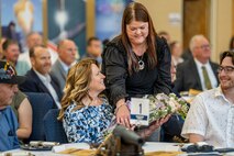 KING GEORGE, Va. – Naval Surface Warfare Center Dahlgren Division Administrative Officer Trina Harris presents flowers to Tina Sisson, wife of Technical Director Dale Sisson Jr., during his retirement ceremony on Friday, June 13 at Round Hill Baptist Church. Sisson retired after 28 years of government service. (Dorina Watermolen/NSWCDD Photo)