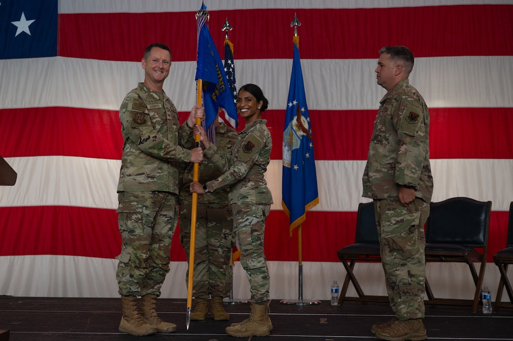 A guidon is passed from one person to another.
