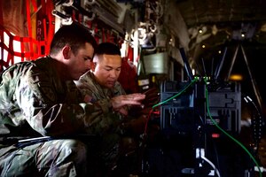 U.S. Air Force Master Sgt. Christopher Marcum and U.S. Army Staff Sgt. Kenneth Babista, enroute engineers with the 4th Joint Communications Support Element, execute test cards with the Joint Deployable Airborne Package at Dyess Air Force Base, Texas, June 2, 2025. The communication upgrades enhance secure, in-flight connectivity for C-130J operations. (U.S. Air Force photo by Senior Airman Emma Anderson)
