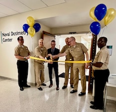 110625-N-NJ594-1001 BETHESDA, Md. (June 11, 2025) – Cmdr. Jeffrey A. Delzer, officer-in-charge of the Naval Dosimetry Center (NDC), cuts the ribbon alongside the Defense Health Agency and NDC leadership to officially open the center’s new, state-of-the-art facility at Walter Reed National Military Medical Center. The event marked a major milestone in NDC’s enduring mission to protect the health and operational readiness of Sailors and Marines across the Fleet.